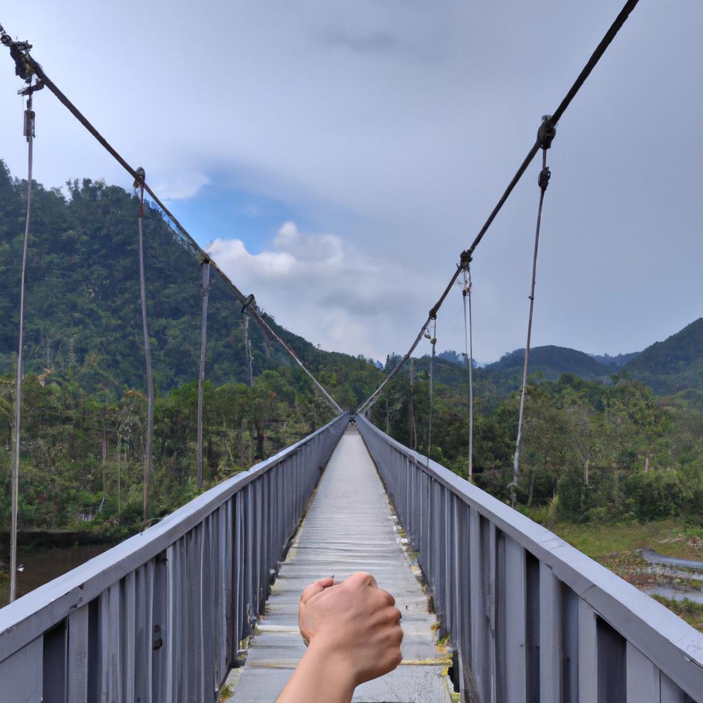 A bridge held by hands with a breathtaking mountain view