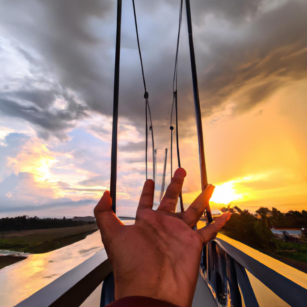 A bridge held by hands with a stunning sunset in the background