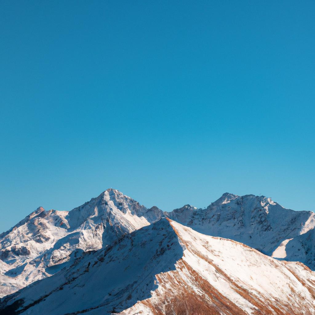The grandeur of life: A stunning mountain range with snow-capped peaks and a clear blue sky