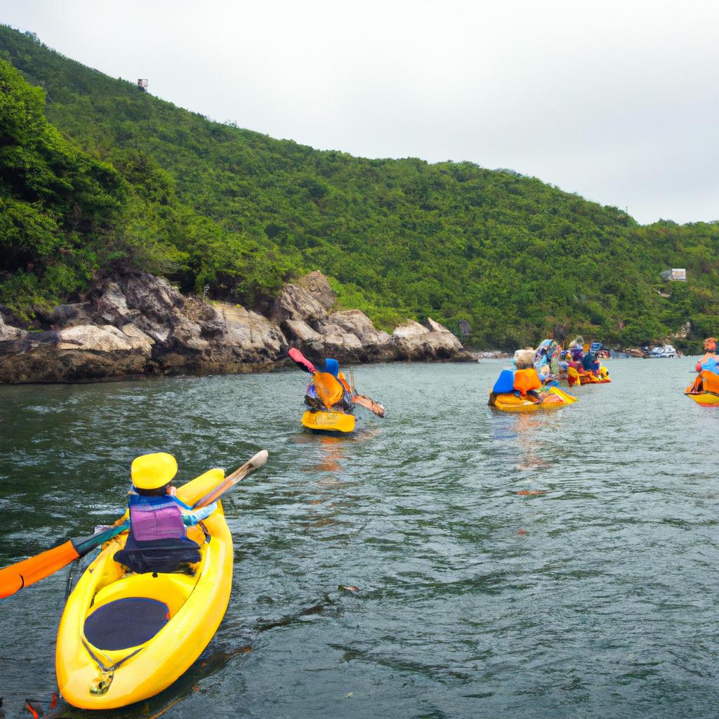 Adventurous tourists kayaking through the limestone cliffs of Vietnam Bay