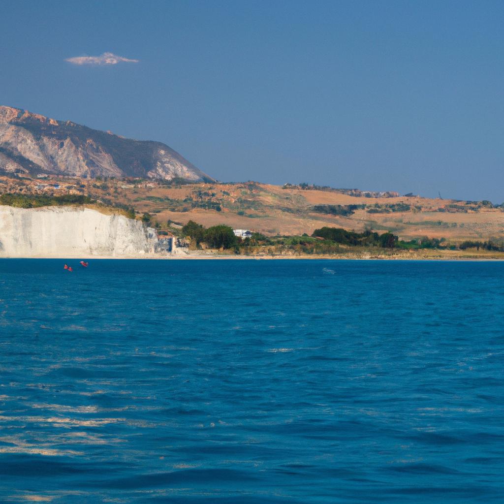 The crystal clear blue sea contrasts perfectly with the White Cliffs of Sicily in the background