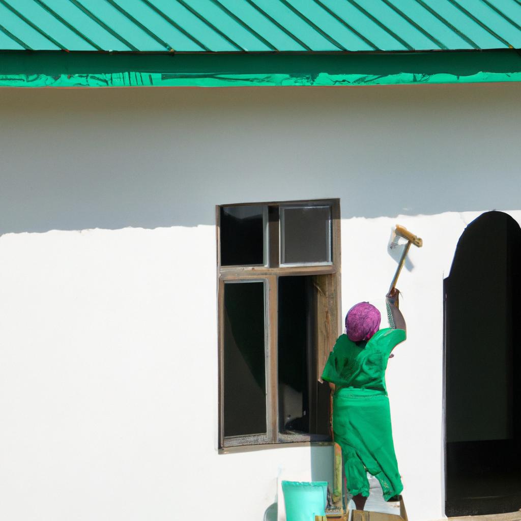 African woman painting the exterior of a house with a brush.